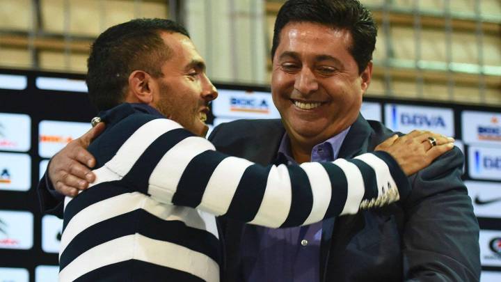 Carlos Tévez y Daniel Angelici se saludan durante una conferencia de prensa.