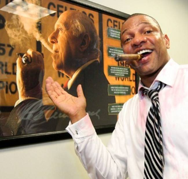 Doc Rivers posó con el puro de la victoria en 2008 junto a un retrato de Red Auerbach