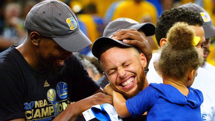 Kevin Durant celebra el anillo de campeones junto a Stephen Curry, quien sostiene en brazos a su hija Riley.