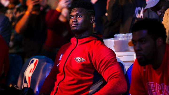 Zion Williamson sentado en el banquillo junto a Derrick Favors