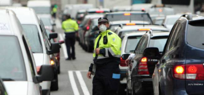 Un policía controla el tráfico con mascarilla por la alta contaminación en Madrid