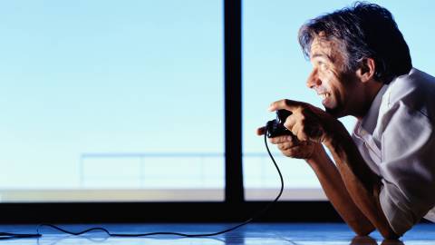 Hombre de unos 40 años jugando con cara de felicidad a los videojuegos