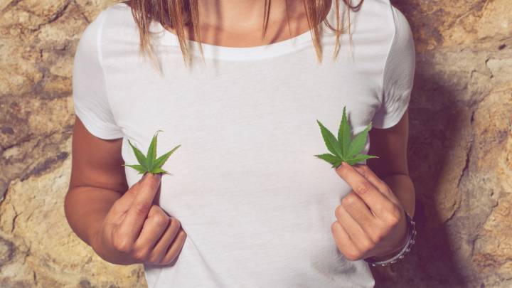 Mujer sosteniendo unas hojas de cannabis en las manos