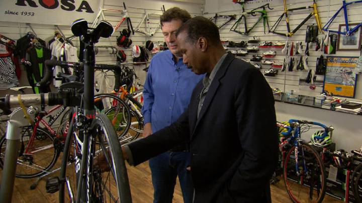 Istvan "Stefano" Varjas le muestra al reportero Bill Whitaker el funcionamiento de los motores en una bicicleta.