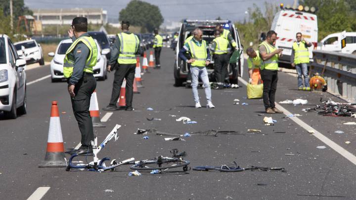 Agentes de la Guardia Civil y miembros de Emergencias en el punto kilométrico 205 de la N-332 entre las localidades de Oliva y Denia, donde la conductora de un turismo ,que ha dado positivo en el control de alcohol y drogas , ha arrollado a un grupo de seis ciclistas de un equipo de Jàvea, provocando la muerte de dos de ellos y heridas graves a otros tres.