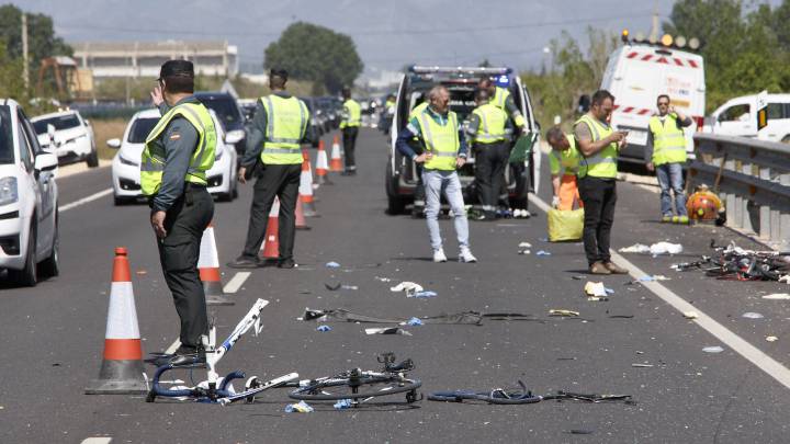 Agentes de la Guardia Civil y miembros de Emergencias en el punto kilométrico 205 de la N-332 entre las localidades de Oliva y Denia, donde la conductora de un turismo ,que ha dado positivo en el control de alcohol y drogas , ha arrollado a un grupo de seis ciclistas de un equipo de Jàvea, provocando la muerte de dos de ellos y heridas graves a otros tres.
