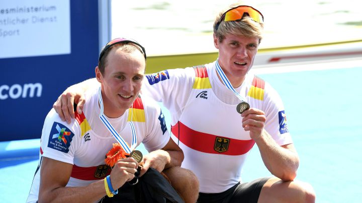 Jonathan Rommelmann y Jason Osborne posan en el podio con la medalla de bronce en los Mundiales de Remo de Linz 2019.