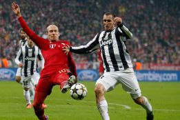 Robben del Bayern Munich y Chielini de la Juventus pugnan por un balón en Champions