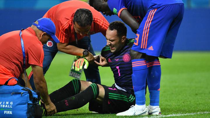 David Ospina es atendido de su tobillo en el juego ante Polonia
