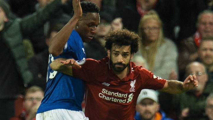 Yerry Mina intenta quitarle la pelota a Salah durante un partido entre Everton y Liverpool por la Premier League