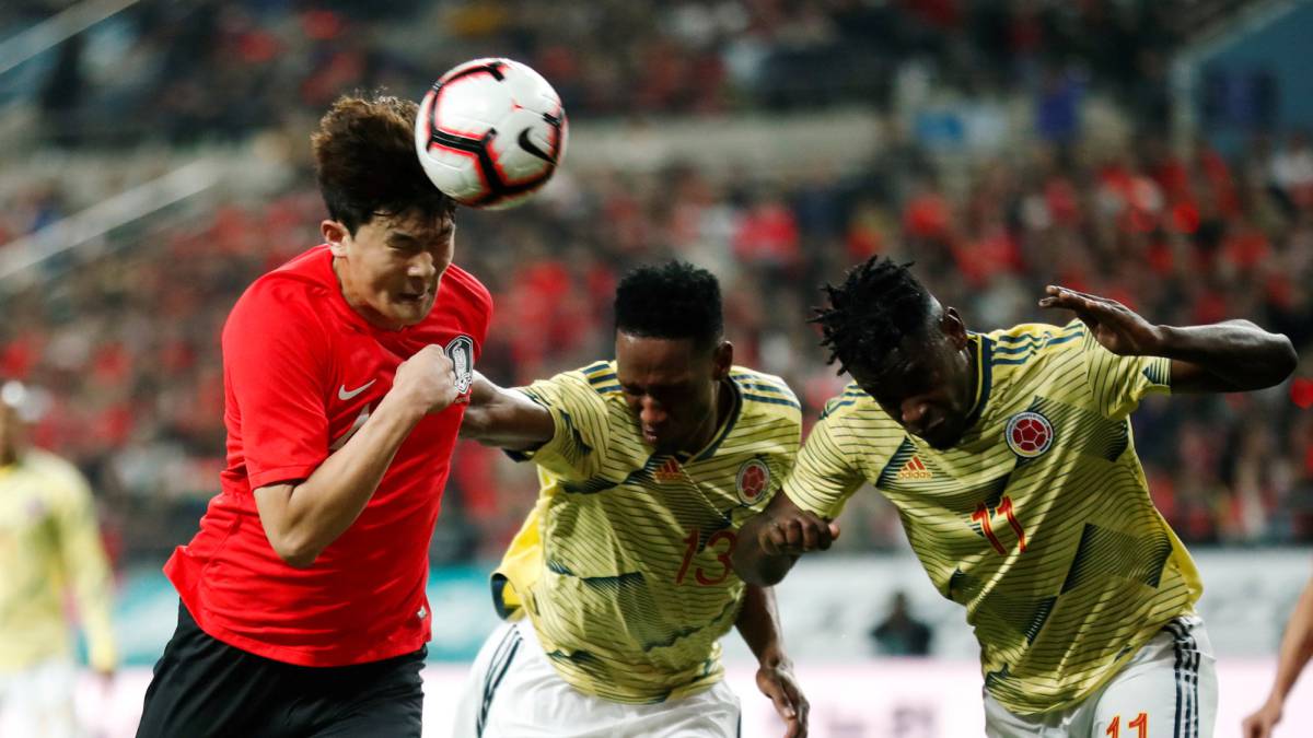 Yerry Mina y Duván Zapata disputan un balón aereo con un jugador coreano.