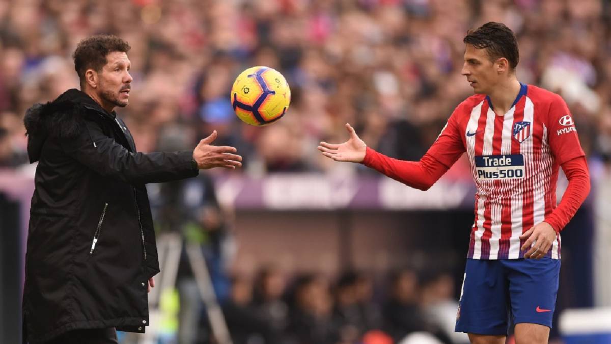 Santiago Arias recibe el balón de la mano de Diego Simeone, técnico de Atlético de Madrid