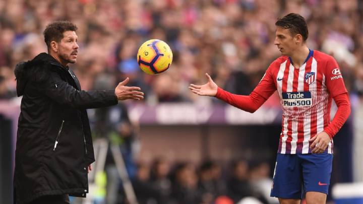 Santiago Arias recibe el balón de la mano de Diego Simeone, técnico de Atlético de Madrid