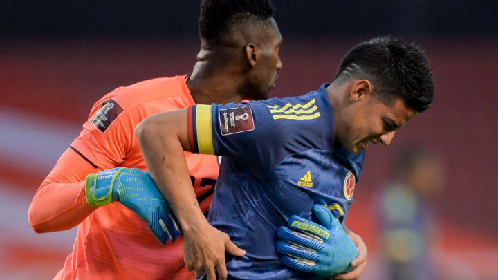 El arquero de Ecuador Alexander Domínguez ayuda a James Rodríguez a pararse en un partido de Eliminatorias