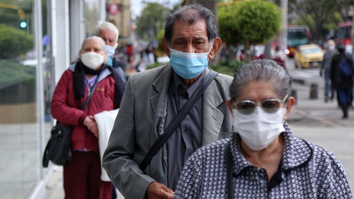 Ciudadanos hacen fila en una calle de Bogotá.