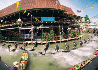 Dominik Gührs se monta en su tabla de wake por el mercado flotante de Bangkok