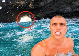 Surfea una ola que pasa por un agujero en un acantilado