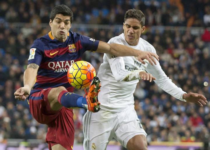 Luis Suárez holds off Raphael Varane at the Bernabéu