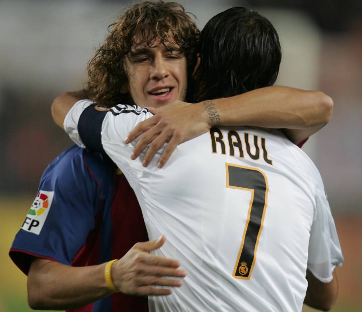 Ex-Barcelona and Real Madrid, Carles Puyol and Raúl González, embrace.