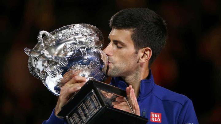 Serbia's Novak Djokovic kisses the men's singles trophy after winning his final match against Britain's Andy Murray at the Australian Open