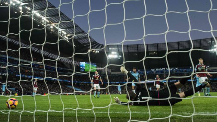 Burnley's English goalkeeper Tom Heaton dives but fails to save a shot from Manchester City's French defender Gael Clichy