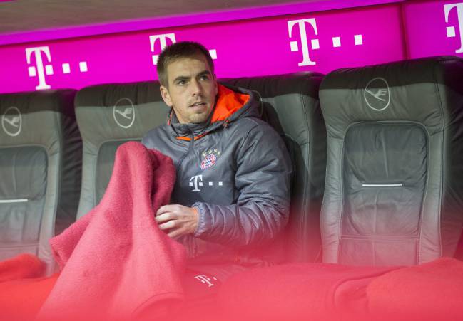 Philipp Lahm of Munich sits on the bench before the German Bundesliga soccer match between FC Bayern Munich and FC Schalke 04