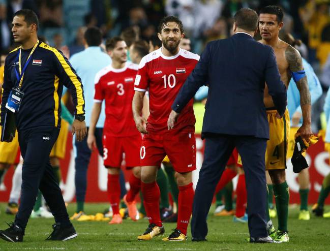 Syria's Firas Mohamad Alkhatib congratulates Australia’s Tim Cahill and head coach Ange Postecoglou.