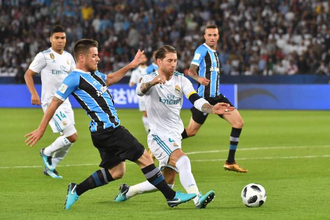 Real Madrid's Spanish captain Sergio Ramos puts in a challenge on Gremio's Brazilian midfielder Ramiro.