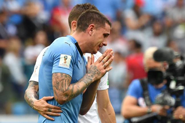France's defender Lucas Hernandez (back) console Uruguay's defender Jose Gimenez during the Russia 2018 World Cup quarter-final football match between Uruguay and France.