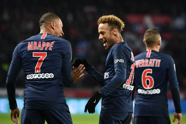 Home for now | PSG's Brazilian forward Neymar celebrates with Kylian Mbappe.