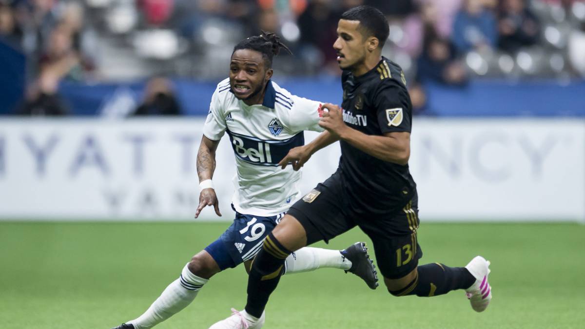 Vancouver Whitecaps forward Alhassane Bangoura vies for control of the ball with Los Angeles FC defender Mohamed El-Munir