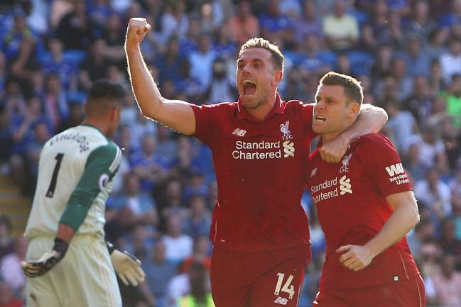 Liverpool's English midfielders Jordan Henderson and James Milner celebrate against Cardiff City.