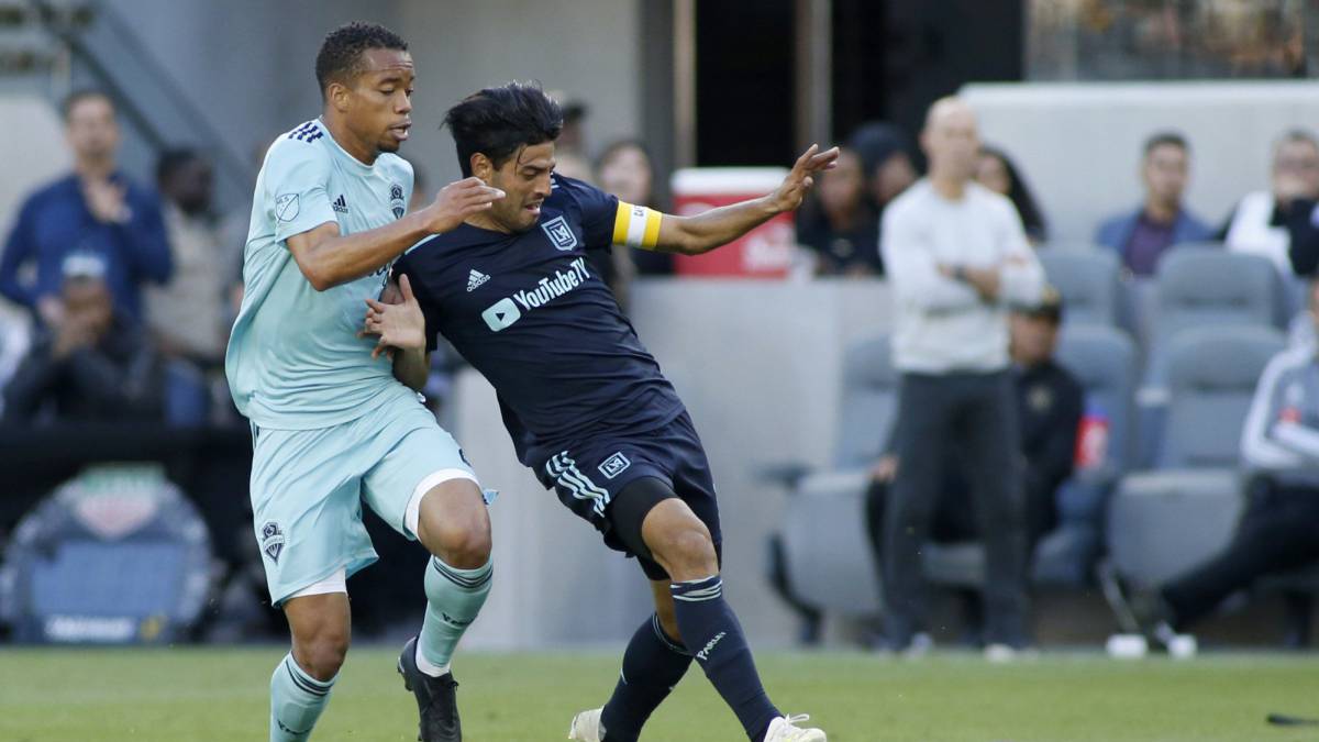 Henry Wingo of Seattle Sounders and Carlos Vela of Los Angeles FC fight for control of the ball during the second half of a game at Banc of California Stadium