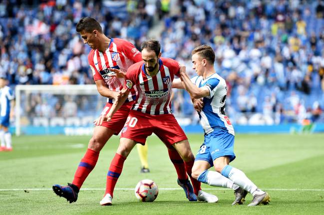 Adria Pedrosa of Espanyol battles for the ball with Atlético's Rodrigo Hernandez Cascante and Juanfran.