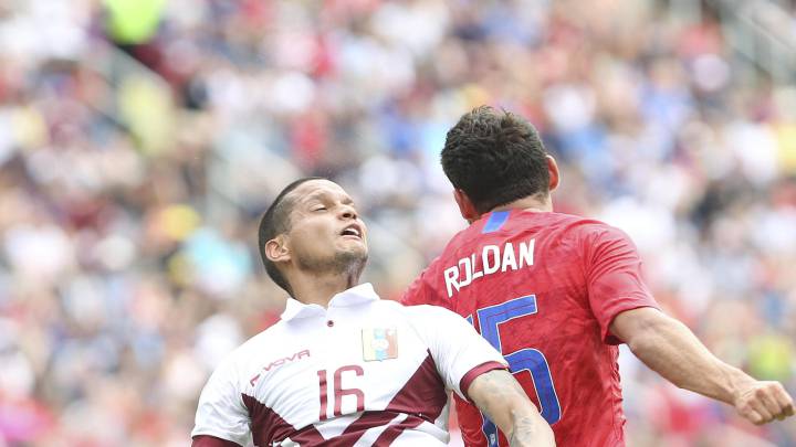 Roberto Rosales (L) of Venezuela fights for the ball with Christian Roldan of the USA during their USA vs Venezuela soccer friendly match at Nippert Stadium