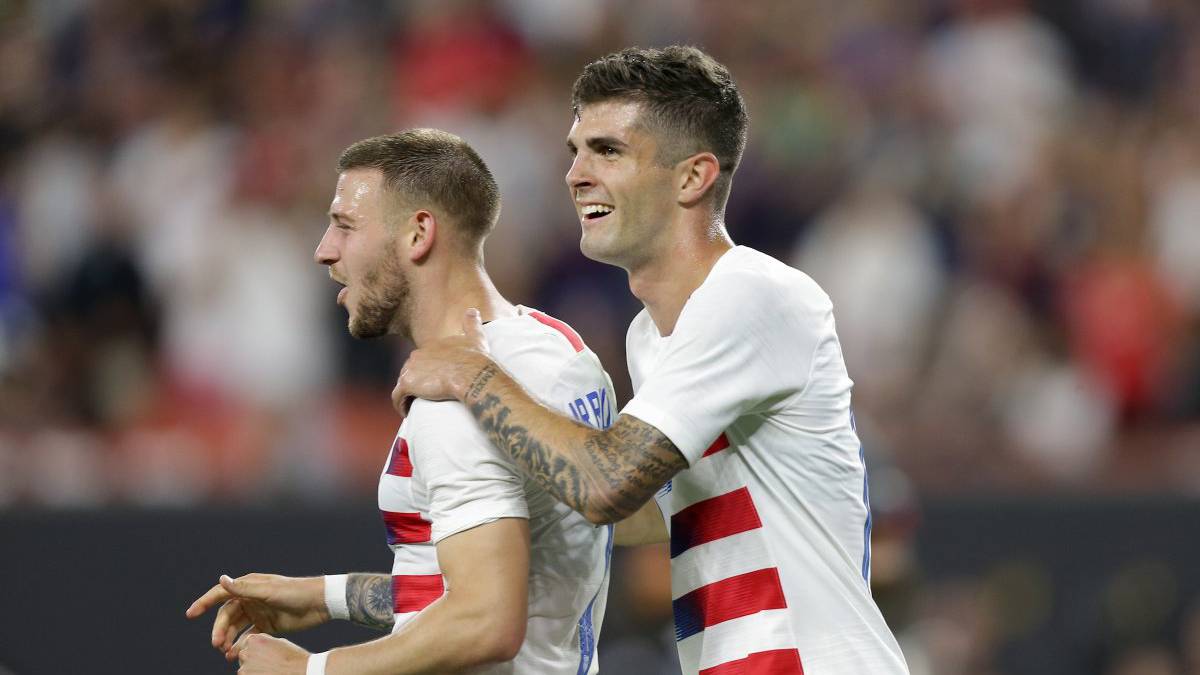 Paul Arriola and Christian Pulisic celebrating after the USMNT win over Trinidad and Tobago