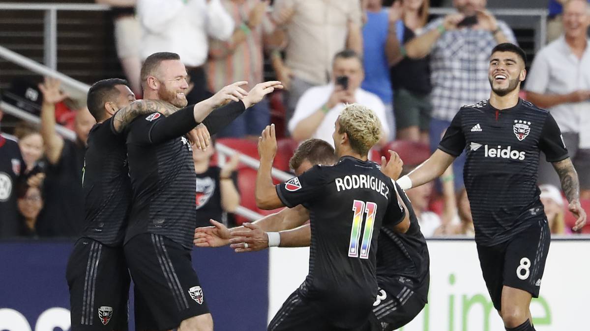 D.C. United forward Wayne Rooney celebrates with teammates after scoring a goal from beyond midfield against Orlando City