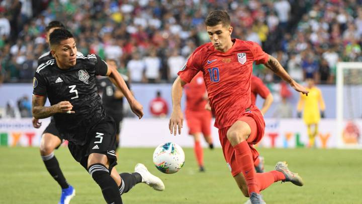 United States midfielder Christian Pulisic chases the ball with Mexico defender Carlos Salcedo in the first half championship match of the CONCACAF Gold Cup
