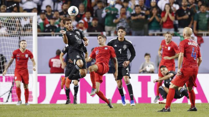 Mexico's midfielder Jonathan dos Santos goes for a header against USA's midfielder Christian Pulisic during the 2019 Concacaf Gold Cup final football match between USA and Mexico