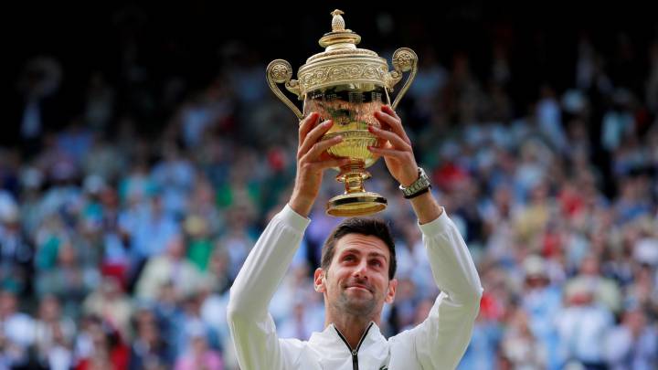 Serbia's Novak Djokovic poses with the trophy as he celebrates winning the final against Switzerland's Roger Federer
