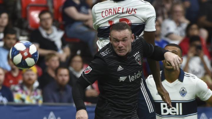 Vancouver Whitecaps defender Derek Cornelius leaps for a header against DC United forward Wayne Rooney during the second half at BC Place