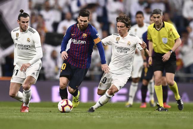 Who'll be fit for the big one? Barcelona's Lionel Messi vies with Real Madrid's Gareth Bale and Luka Modric in March.
