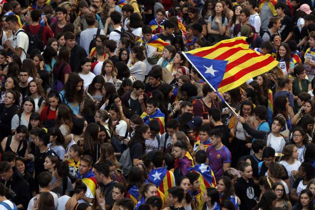 Students wave a Catalan pro-independence "estelada" flag as they protest during a demonstration in front of the police headquarters in Barcelona on October 17, 2019.