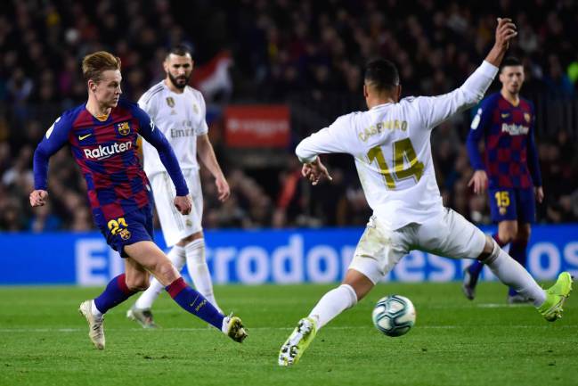 Barcelona's Dutch midfielder Frenkie De Jong challenges Real Madrid's Brazilian midfielder Casemiro during the "El Clásico".