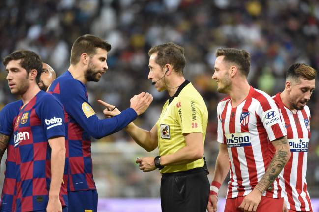 Disagreements | Barcelona's Spanish defender Gerard Pique argues with the referee.