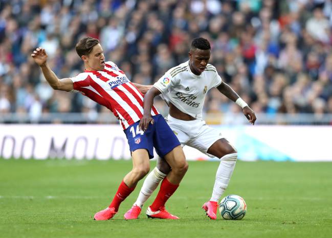 Marcos Llorente held off by Vinicius during the Madrid derby.