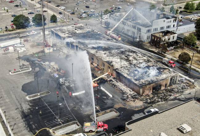 An aerial photo made with a drone shows firefighters battling fires set near the Minneapolis police 3rd Precinct, during a third day of protests over the arrest of George Floyd.