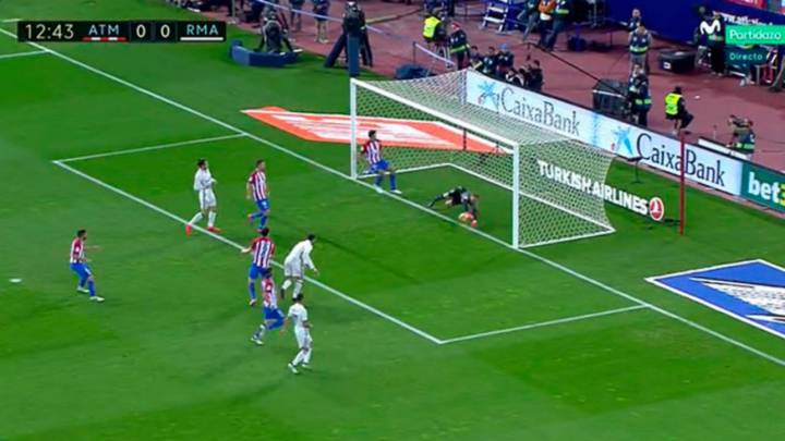 Cristiano, jugador del Real Madrid, remata y Oblak, portero del Atlético de Madrid, saca una gran mano para evitar el gol.