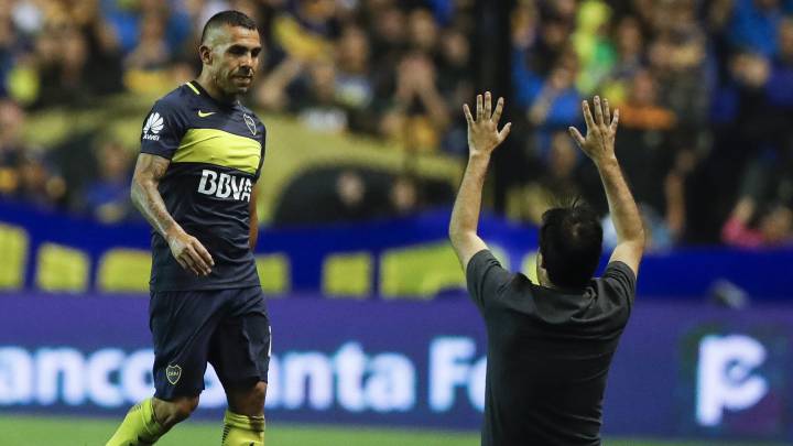 Un aficionado salta al campo para abrazarse a Tevez.