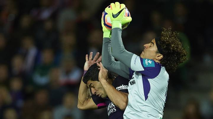 Ochoa atrapa un balón ante Luis Suárez.